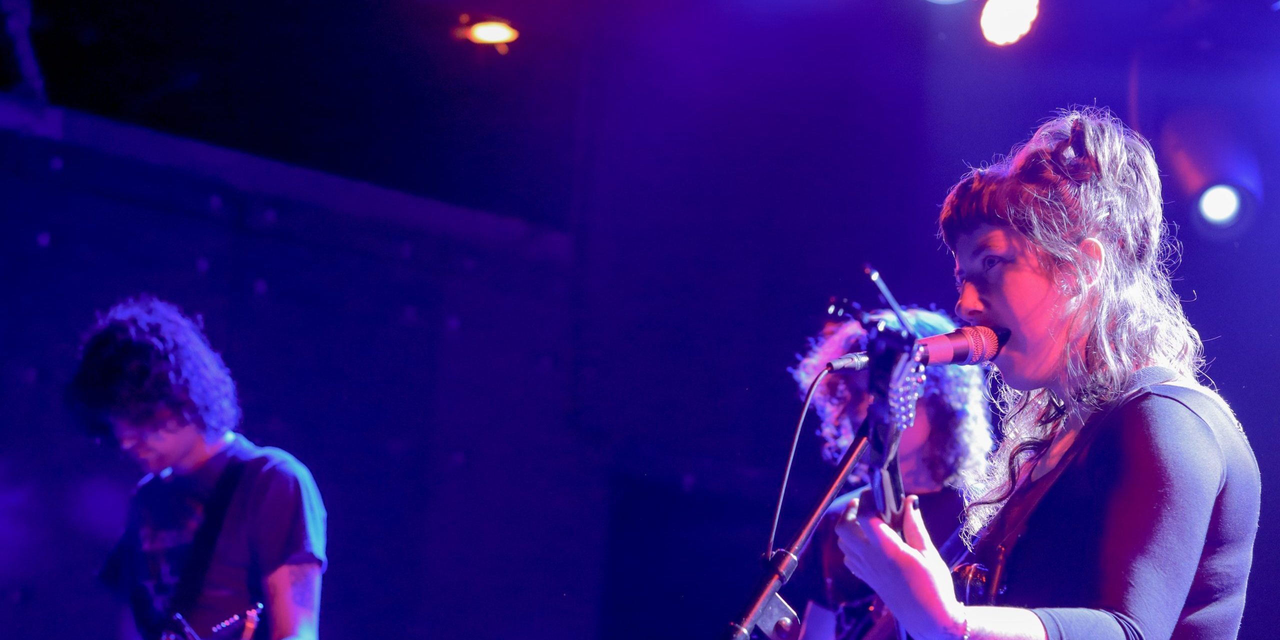 Wednesday-1 Karly Hartzman on stage with band members Ethan Baechtold and MJ Lenderman