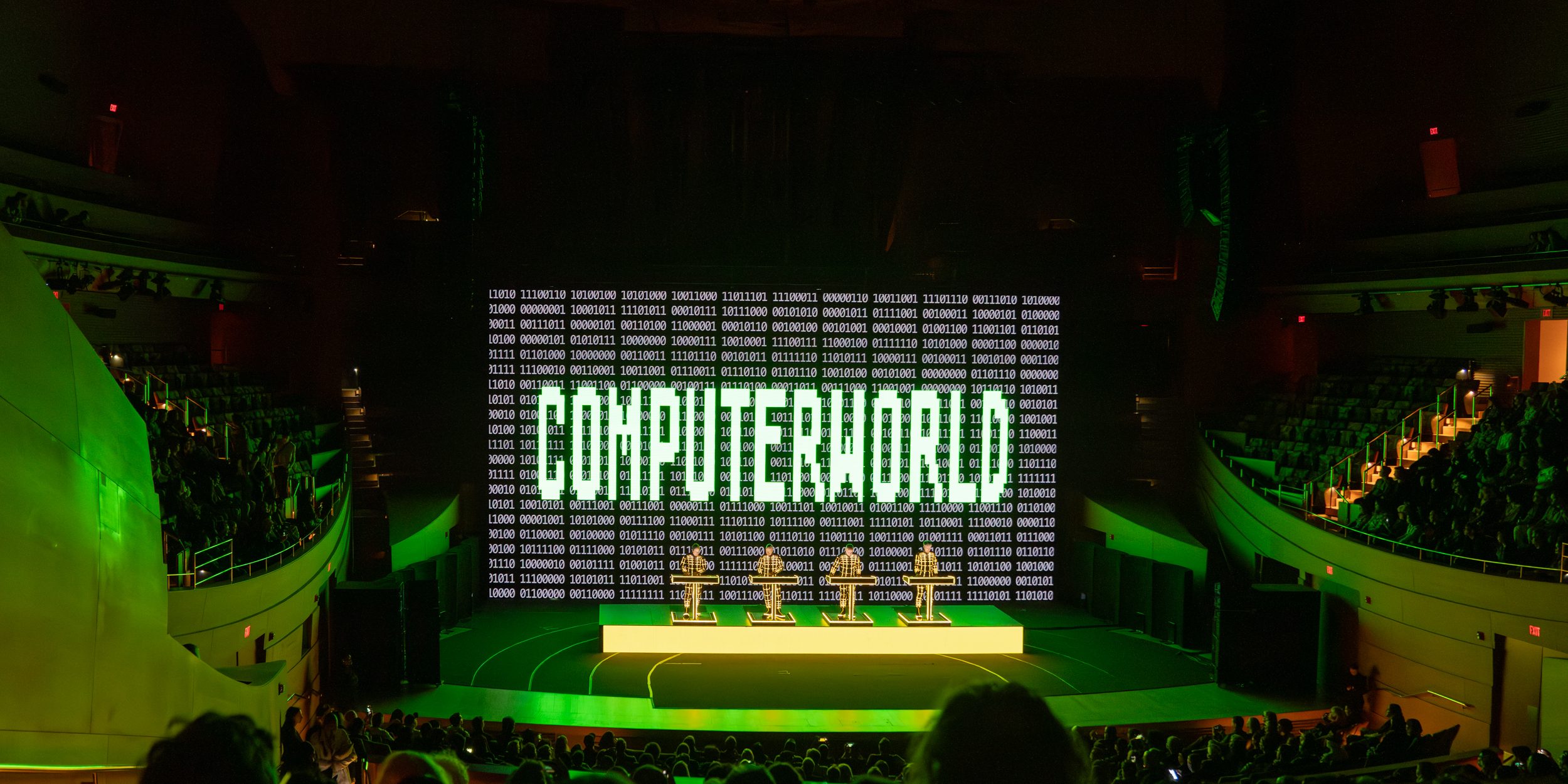 Kraftwerk at the Walt Disney Concert Hall, in front of a large cinematic screen which reads "COMPUTERWORLD."