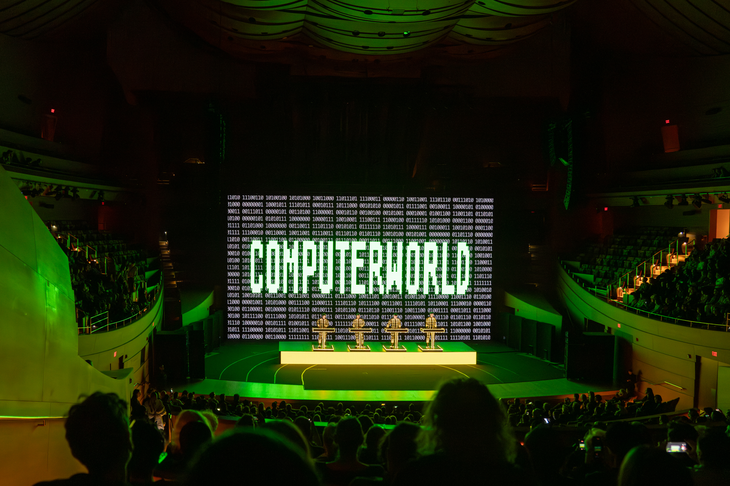 Kraftwerk at the Walt Disney Concert Hall, in front of a large cinematic screen which reads "COMPUTERWORLD."
